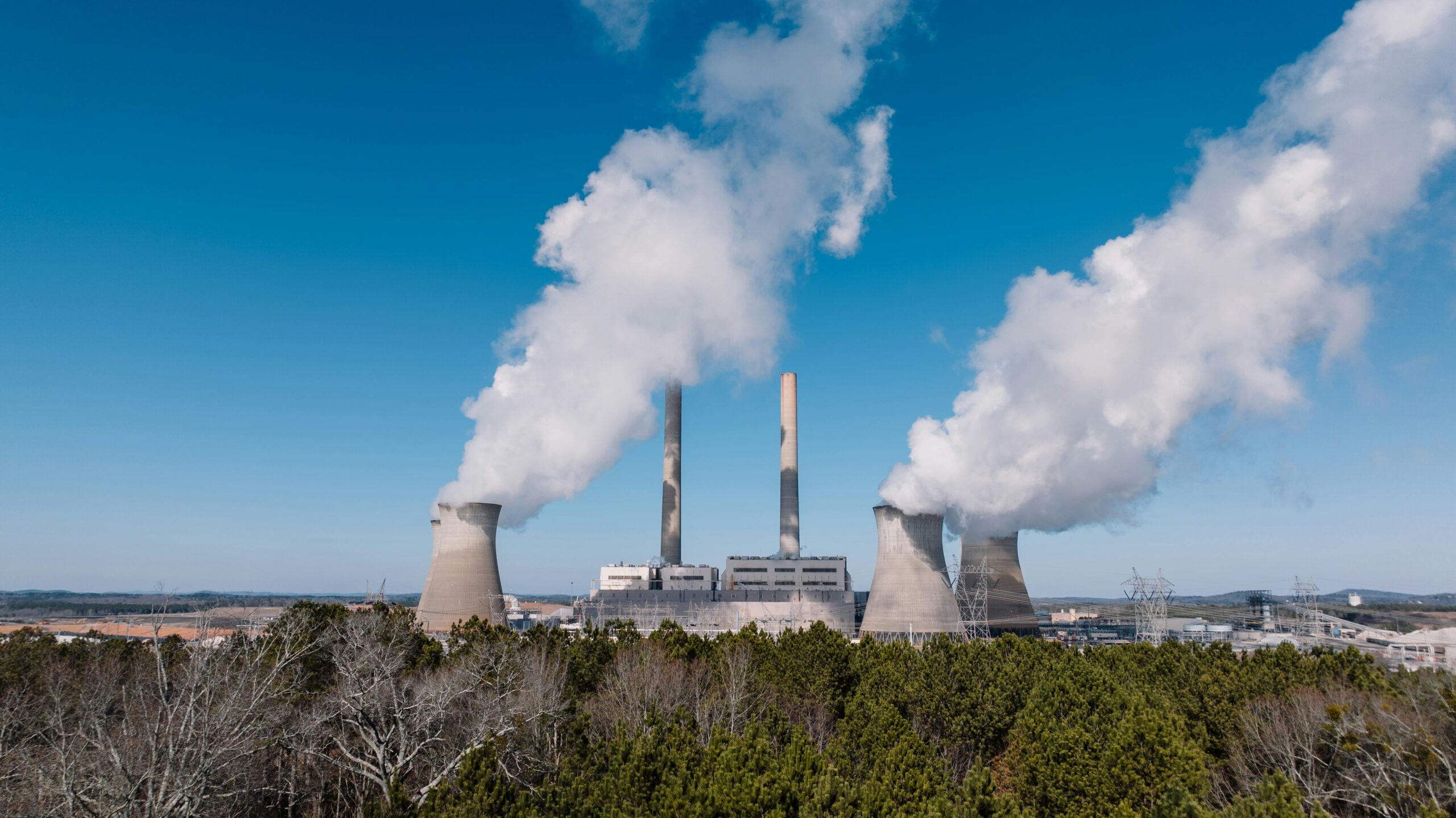 Aerial view of an industrial plant emitting smoke against a clear blue sky in Cartersville, Georgia.