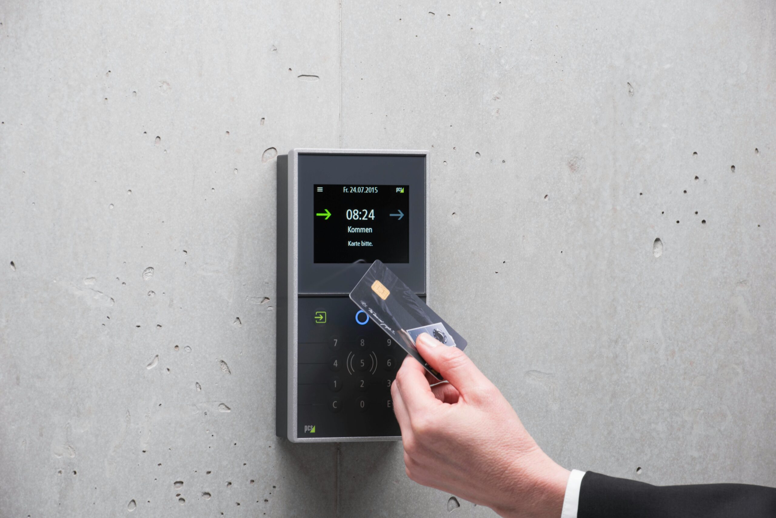 A businessman uses a secure card reader access system against a concrete wall.